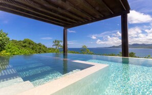 An infinity pool with clear water, surrounded by lush greenery and a view of the ocean. - Estate La Sierra in Punta Mita (Punta de Mita)