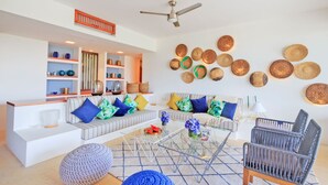 A modern living room with a sofa set, a coffee table, and a wall decorated with woven baskets. - Condo Terramar in Punta Mita (Punta de Mita)