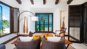 A room with wicker furniture, a round wooden table, and a view of the beach through large windows. - Condo Clavel in Punta Mita (Punta de Mita)