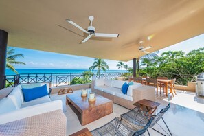 A balcony with outdoor furniture, a ceiling fan, and a view of the ocean. - Condo Clavel in Punta Mita (Punta de Mita)