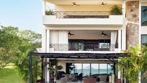 A two-story house with a covered patio, outdoor furniture, and a view of the ocean. - Condo Clavel in Punta Mita (Punta de Mita)