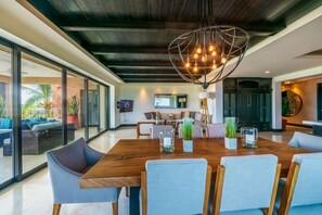 Un comedor amplio con una mesa de madera, sillas y una lámpara con un diseño geométrico único.