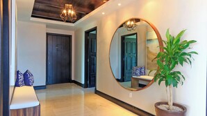 A hallway with a wooden ceiling, a round mirror, a potted plant, and a bench with patterned cushions. - Condo Aralia in Punta Mita (Punta de Mita)