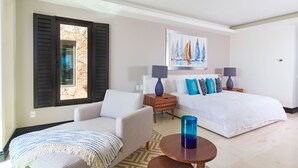 A hotel room with a bed, two bedside tables, a chair, a lamp, a painting, and a window with shutters. - Condo Aralia in Punta Mita (Punta de Mita)
