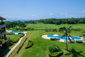 A golf course with multiple swimming pools, well-manicured lawns, and a clear view of the ocean. - Condo Jazmin in Punta Mita (Punta de Mita)