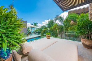 Eine moderne Lounge-Bereich im Freien mit Pool, Topfpflanzen und freiem Blick zum Himmel.