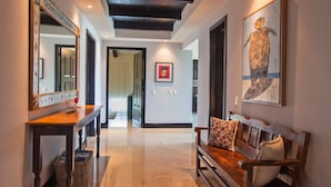A hallway with a wooden bench, a mirror, and artwork on the walls. - Condo Gerbera in Punta Mita (Punta de Mita)