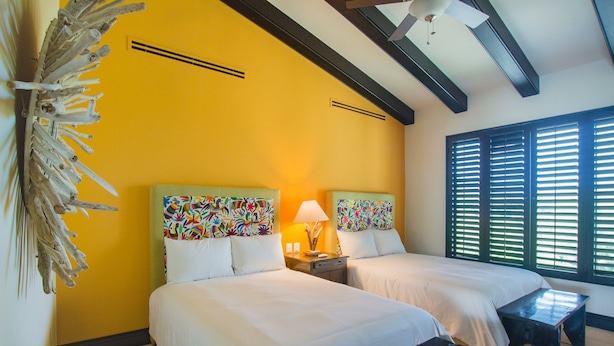 A hotel room with two beds, a wooden bench, a decorative wall piece, and a window with blinds. - Condo Gerbera in Punta Mita (Punta de Mita)