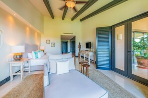A modern hotel room with a bed, bedside tables, a desk, and a ceiling fan. - Condo Gerbera in Punta Mita (Punta de Mita)