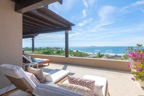 A balcony with a view of the sea, a covered seating area, and a potted plant. - Penthouse Bugambilia (Punta de Mita)