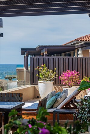 A balcony with a view of the sea, a wooden fence, and potted plants. - Penthouse Bugambilia (Punta de Mita)