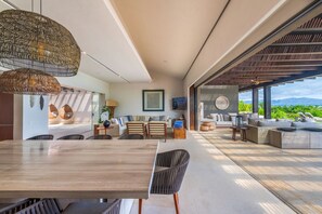 A modern interior with a dining area, seating, and a view of the outdoors. - Villa Vista Hermosa in Punta Mita (Punta de Mita)