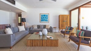 A modern living room with a grey sofa, a wooden coffee table, and a ceiling fan. - Condo Palma Azul in Punta Mita (Punta de Mita)