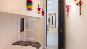 A narrow hallway with a bunk bed, a door leading to another room, and a wall-mounted lamp. - Condo Palma Azul in Punta Mita (Punta de Mita)