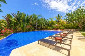 A swimming pool with lounge chairs and a potted plant. - Condo Palma Azul in Punta Mita (Punta de Mita)