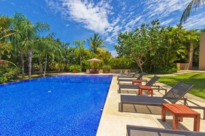 A swimming pool with lounge chairs and a pergola. - Condo Palma Azul in Punta Mita (Punta de Mita)
