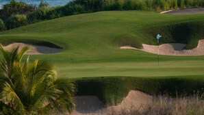 A golf course with a flagstick, sand bunkers, and a view of the ocean. - Villa Aguamarina in Punta Mita (Punta de Mita)