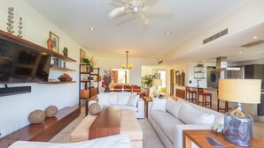 A spacious living area with a sofa, coffee table, and TV. - Villa Aguamarina in Punta Mita (Punta de Mita)