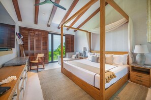 A four-poster bed with a canopy, a wooden desk with a chair, and a nightstand with a lamp. - Villa Mataiza in Punta Mita (Punta de Mita)