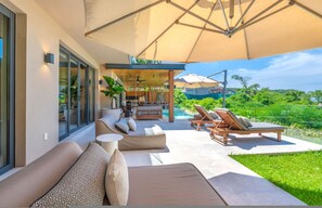 A modern outdoor living area with a pool, lounge chairs, and a covered patio. - Villa Mataiza in Punta Mita (Punta de Mita)