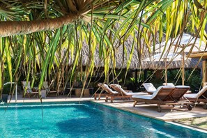 A pool area with lounge chairs and a thatched roof structure. - Villa Aire in Punta Mita (Punta de Mita)