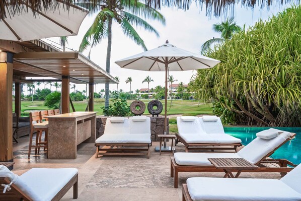 A poolside lounge area with wooden loungers, a bar, and a view of a golf course. - Villa Aire in Punta Mita (Punta de Mita)
