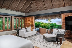 A modern bedroom with a large bed, a sofa, a dining table, and wicker furniture. - Villa Aire in Punta Mita (Punta de Mita)
