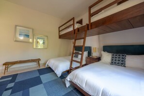 A room with two beds, a wooden ladder, a bench, and two framed pictures on the wall. - Villa Diamante in Punta Mita (Punta de Mita)