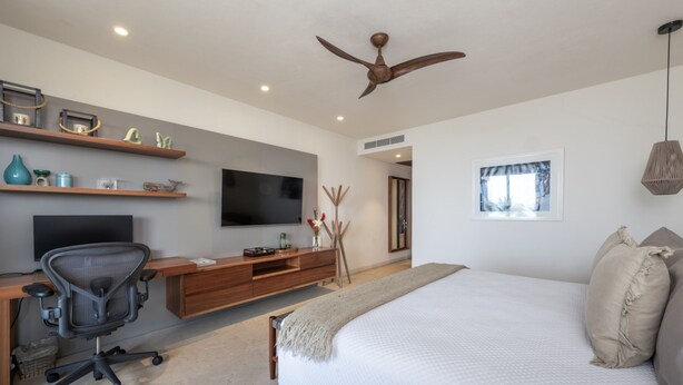 A bedroom with a bed, a desk with a chair, a television, and a ceiling fan. - Condo Kumar in Punta Mita (Punta de Mita)