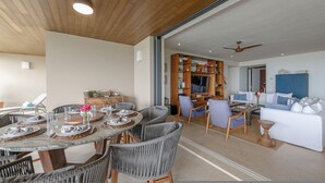 A spacious living area with a dining table set for six, surrounded by wicker chairs. - Condo Kumar in Punta Mita (Punta de Mita)