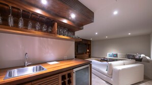 A modern kitchen with a built-in wine rack, a stainless steel sink, and a built-in refrigerator. - Casa Marlago in Punta Mita (Punta de Mita)