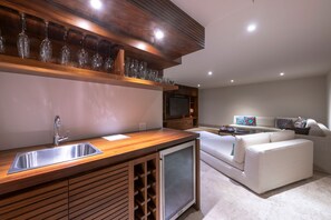 Eine moderne Küche mit integriertem Weinkühlschrank, einer Edelstahl-Spüle und einem Einbaukühlschrank.