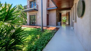 A modern two-story house with a balcony, a garden, and a pathway leading to the entrance. - Casa Marlago in Punta Mita (Punta de Mita)