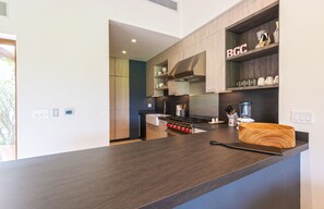 Eine moderne Küche mit Holzausstattung, einem eingebauten Herd und einer Arbeitsplatte mit einer Holzschüssel.