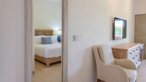 Une chambre à coucher avec un lit, une chaise, un bureau et un téléviseur.