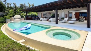 A modern outdoor pool area with a hot tub, lounge chairs, and a covered patio. - Casa Rincon del Mar in Punta Mita (Punta de Mita)