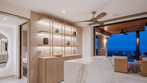A modern kitchen with marble countertops, wooden cabinetry, and a balcony with a view of the ocean. - Condo La Joya in Punta Mita (Punta de Mita)
