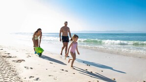 A beach scene with a family walking along the shore. - Casa Familia in Punta Mita (Punta de Mita)