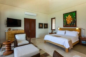 A bedroom with a bed, a television, a painting, a desk, and a chair. - Casa Familia in Punta Mita (Punta de Mita)
