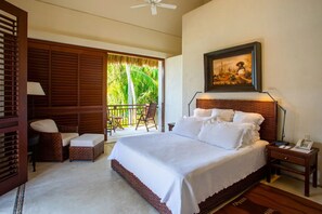 A bedroom with a large bed, a balcony with wicker furniture, a painting on the wall, and a ceiling fan. - Casa Familia in Punta Mita (Punta de Mita)