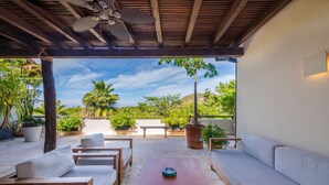 An outdoor patio with wooden furniture, a ceiling fan, and potted plants. - Penthouse Pacifico in Punta Mita (Punta de Mita)