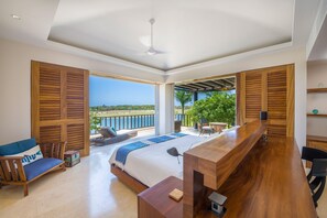 A bedroom with a large bed, wooden shutters, a desk, and a view of the outdoors. - Condo Lago in Punta Mita (Punta de Mita)
