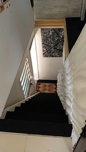 A staircase with a black handrail and a patterned wall at the top. - Villa top studio (BAIE MAHAULT)