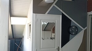 Ett rum med en takfläkt, en klocka och en dörr som leder till ett annat rum.