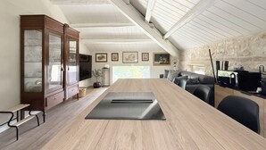 A modern kitchen with a wooden countertop, a built-in stove, and a stone wall. - N315 – Numana, new, fully equipped two-room apartment (Numana)