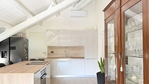 A modern kitchen with a wooden countertop, stainless steel appliances, and a built-in oven. - N315 – Numana, new, fully equipped two-room apartment (Numana)