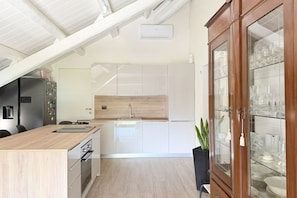 Eine moderne Küche mit einer Holz Arbeitsplatte, Edelstahlgeräten und einem eingebauten Backofen.