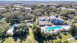 A residential area with a large house featuring a swimming pool and a tennis court. - Bahama Bay Resort - Ground Floor (Davenport)