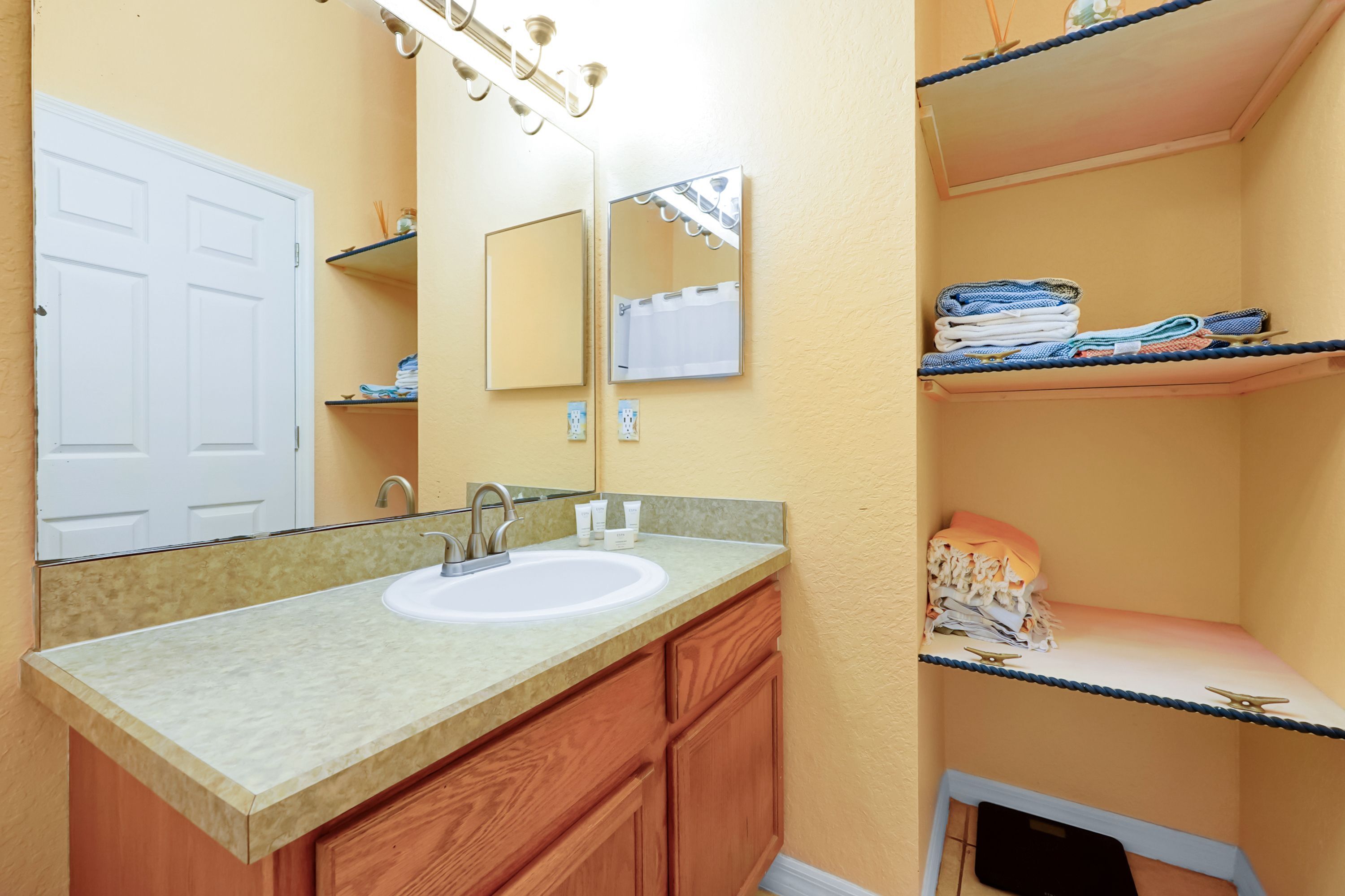 Une salle de bain avec un lavabo, un miroir et des meubles en bois.