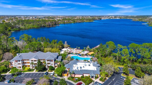 A resort with a swimming pool, multiple buildings, and a large body of water. - Bahama Bay Resort Penthouse w Lake View 15209 (Davenport)